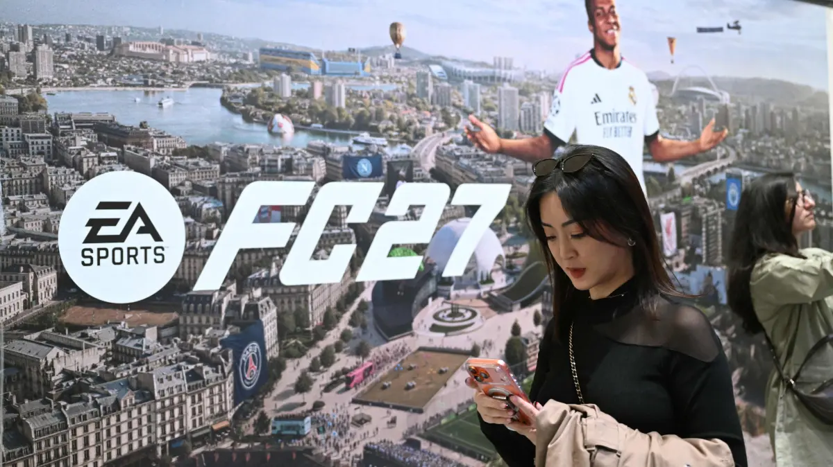 GERMANY-GAMING-FAIR-GAMESCOM: A gamer walks past the EA SPORTS FC 27 video game of Electronic Arts with French soccer player Kylian Mbappe at the Gamescom video games trade fair on the fair grounds in Cologne, western Germany, on August 26, 2026. The 2026 edition of the vast Gamescom trade fair had its opening night on August 25, 2025 and will be running from August 26 to 30, 2026. (Photo by Ina FASSBENDER / AFP)