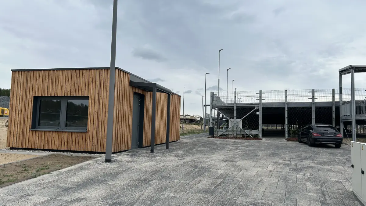 An diesem kleinen Häuschen am neuen Bahnhof Fangschleuse nahe der Tesla Gigafactory Berlin-Brandenburg gehen Reisende vorbei, die mit dem Auto zum Bahnhof fahren. Welche Funktion hat das Gebäude?
