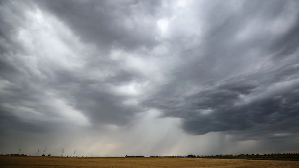 Wetterwechsel steht bevor: ARCHIV - 19.07.2023, Sachsen-Anhalt, Lützen: Eine Regenfront zieht über ein Getreidefeld hinweg. (zu dpa: «Heute noch sonnig - dann drohen Schauer und Gewitter») Foto: Jan Woitas/dpa +++ dpa-Bildfunk +++