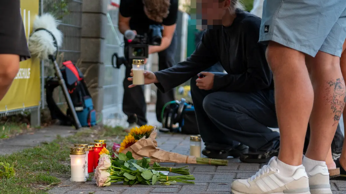Vor der Schule an der Berliner Straße legen Schüler und Anwohner am Abend Blumen nieder und zünden Kerzen an.