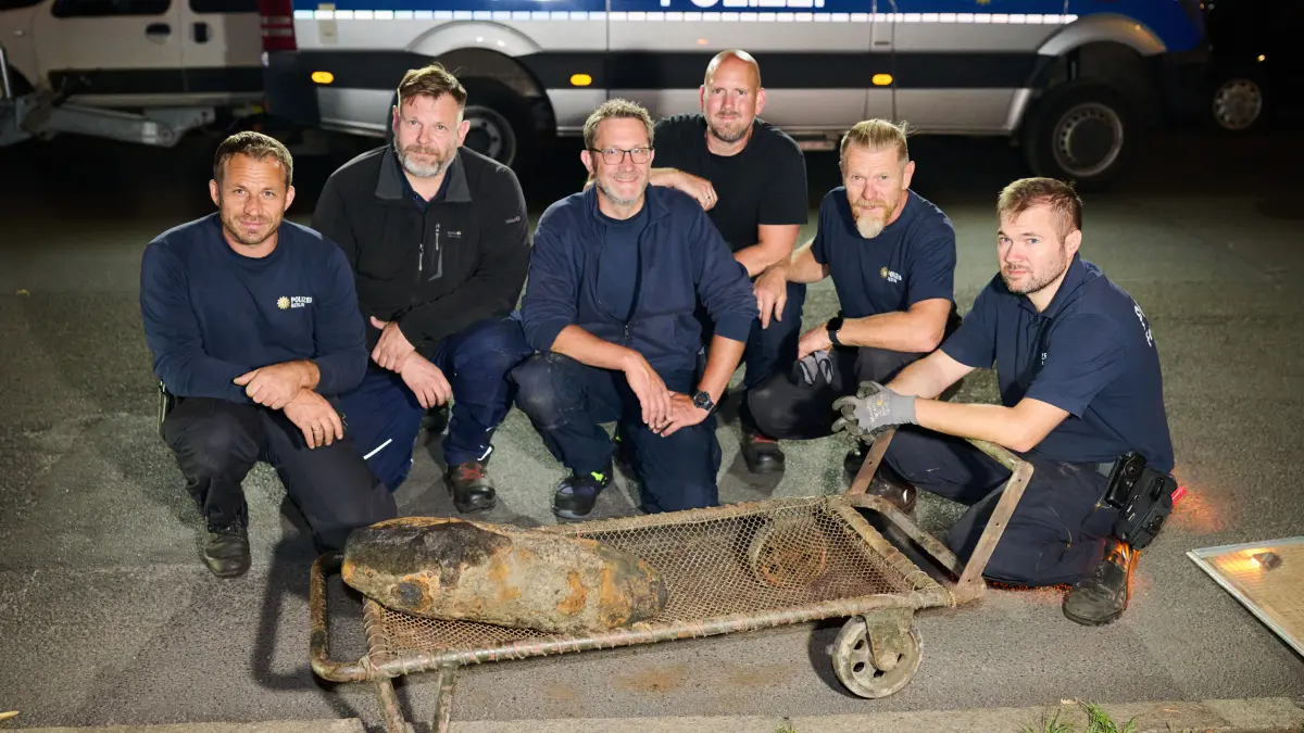 Polizeibeamte des Kampfmittelbeseitigungsdienstes sitzen an der entschärften Bombe in Berlin-Neukölln. Im Kanal wurde eine Fliegerbombe aus dem Zweiten Weltkrieg gefunden.