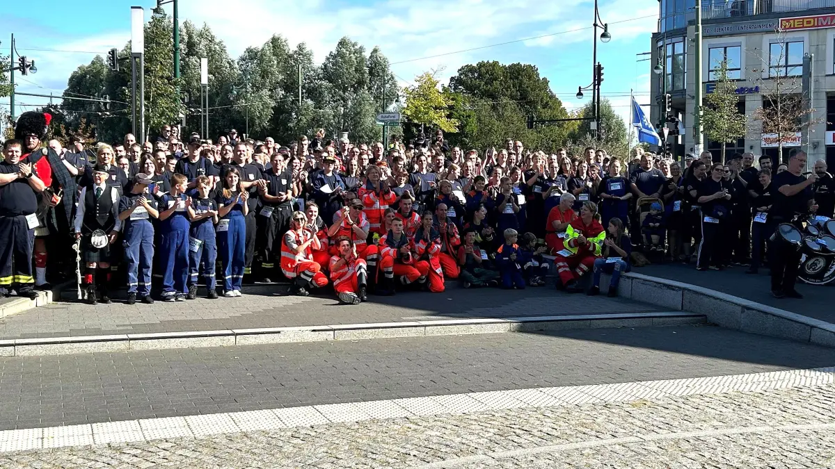 Gruppenbild im Zentrum von Eberswalde: Die Teilnehmer des Blaulichtmarsches haben auf der Treppe zur Kreuzung an der Friedensbrücke Aufstellung genommen.