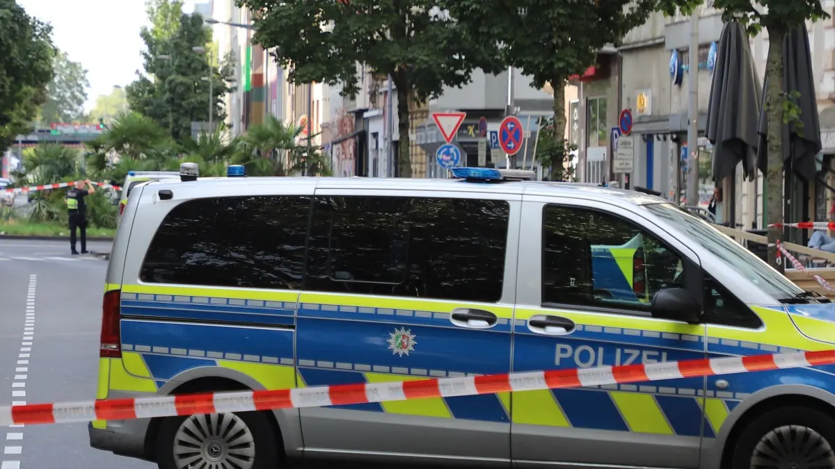 Schüsse auf Café in Kölner Südstadt: 31.08.2026, Nordrhein-Westfalen, Köln: Ein Fahrzeug der Polizei steht hinter einer Absperrung auf einer Straße. Schüsse auf ein Café in der Kölner Südstadt haben am Morgen für einen Großeinsatz der Polizei gesorgt - die Einsatzkräfte fahnden nach einem Täter. Verletzte oder Tote gibt es laut Polizeiangaben nicht. Foto: ---/dpa +++ dpa-Bildfunk +++