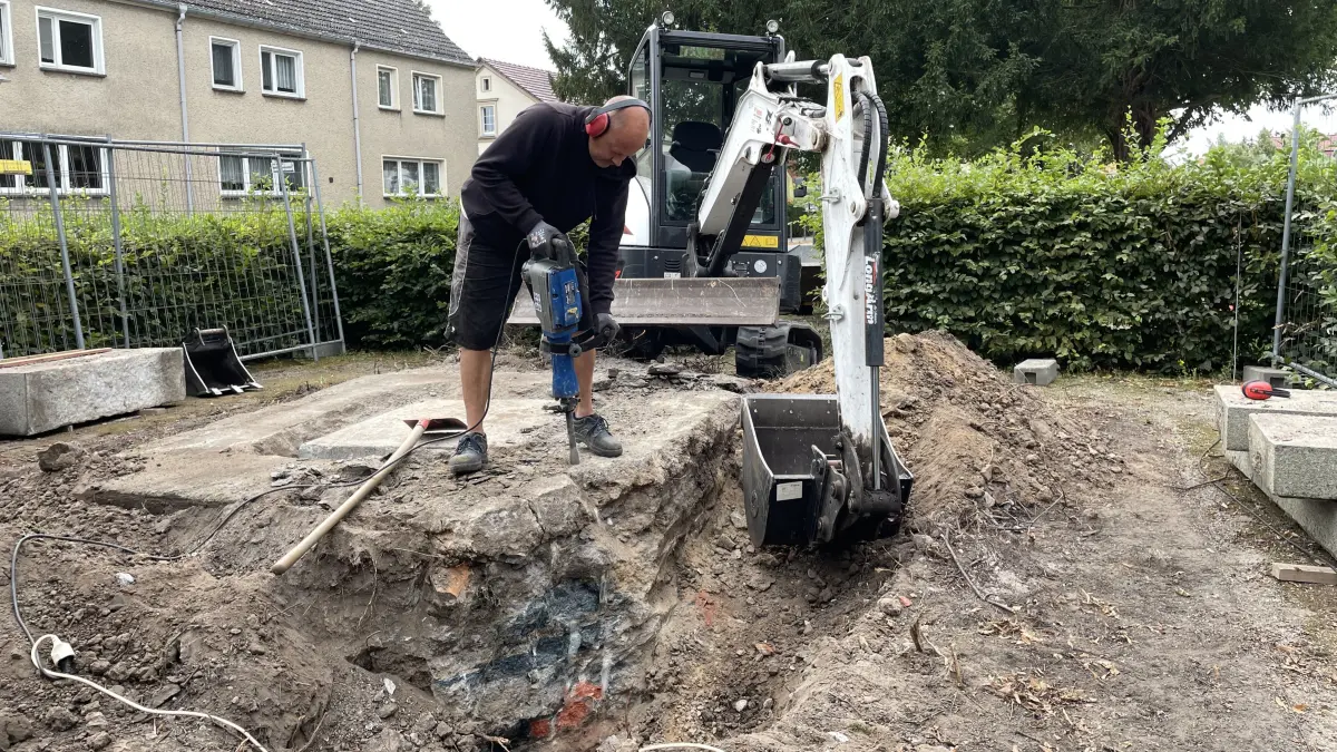 Spurensuche auf dem Anger in Letschin: Janko Zimmermann und Patrick Gelhaar von der Firma Baumgarten haben am 3. September den alten Sockel des Friedrich-Denkmals abgerissen. Darunter sollte sich im Fundament der Grundstein befinden.