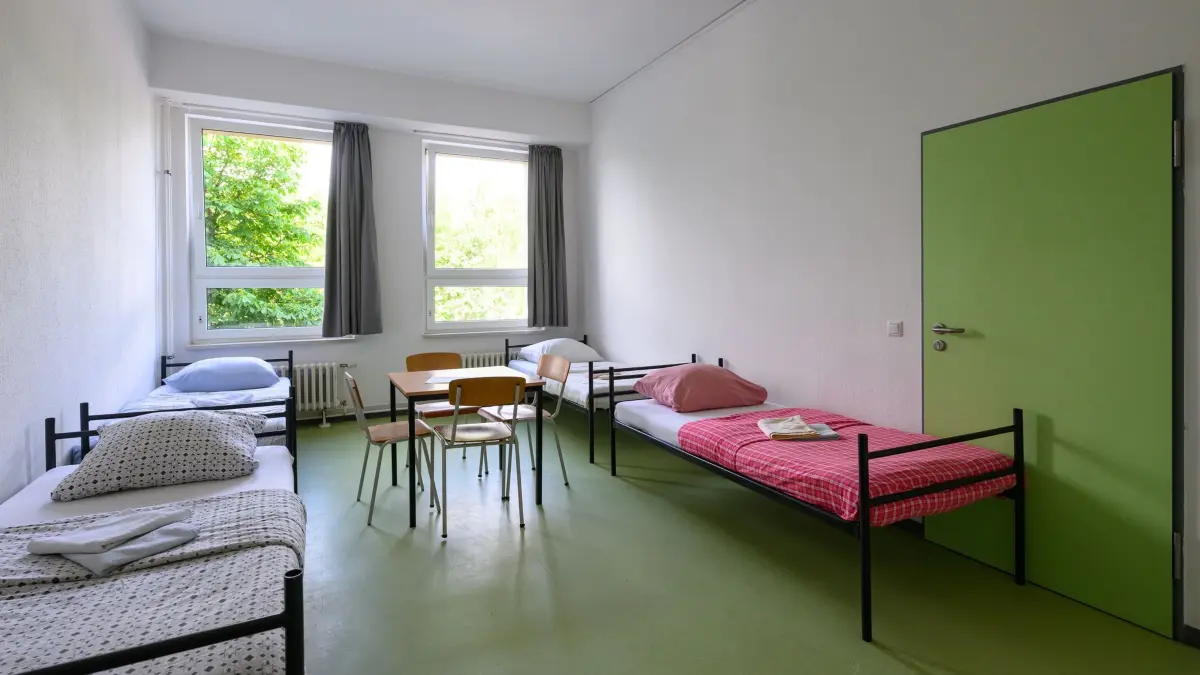 Gemeinschaftsunterkunft: ARCHIV - 04.06.2026, Brandenburg, Frankfurt (Oder): Betten und ein Tisch stehen in einem Wohnraum für Geflüchtete in einer Gemeinschaftsunterkunft. (zu dpa: «Asylbewerber-Unterkünfte deutlich geringer belegt») Foto: Patrick Pleul/dpa +++ dpa-Bildfunk +++