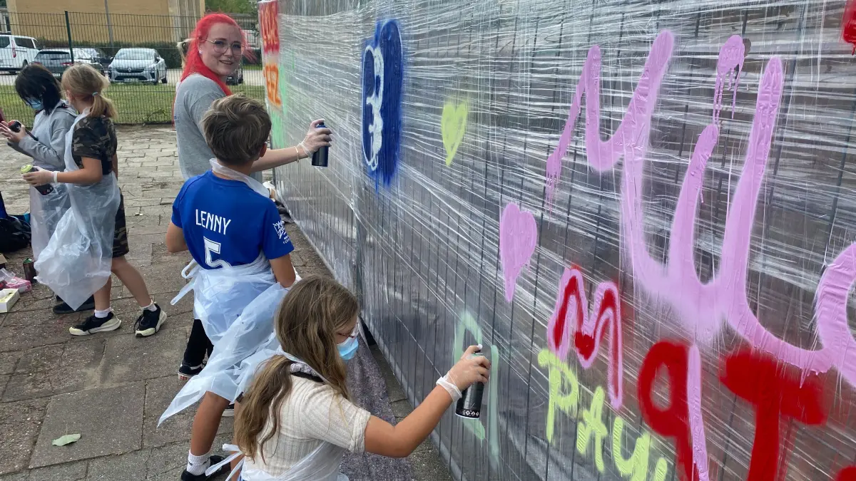 Gestalten zum fünfjährigen Bestehen des Kinder- und Jugendfreizeitzentrums eine Wand: Kinder unter Anleitung der Erieherin Jeanine Moroz