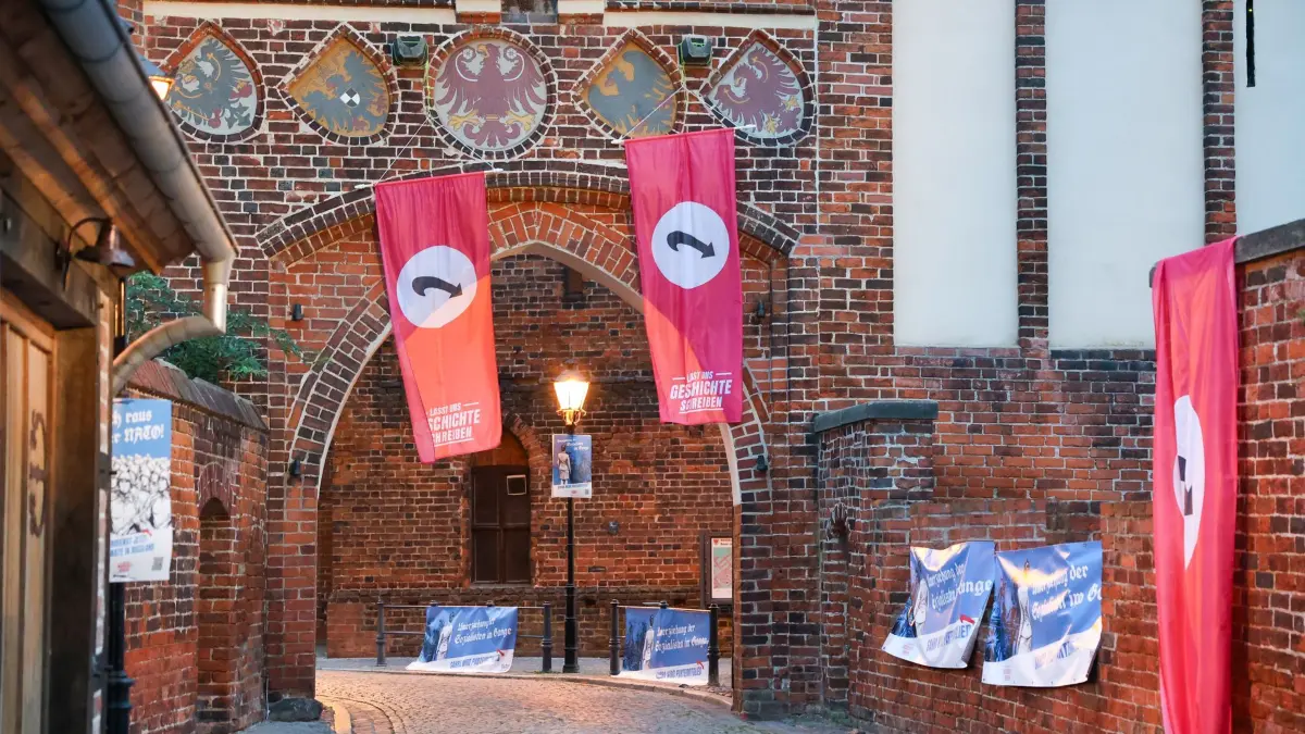 Demokratische Kunstinstallation: 04.09.2026, Sachsen-Anhalt, Tangermünde: Mitglieder vom «Gemeinschaftsbund Demokratischer Deutscher für ein zukunftsfähiges Sachsen-Anhalt» installierten am Morgen in Tangermünde Plakate und Bannerflaggen an Geschäften und Gebäuden.
Dahinter steckt ein Verbund aus Menschen verschiedenster politischer Richtungen, die sich Sorgen um die Zukunft Sachsen-Anhalts machen und kurz vor der Wahl darauf aufmerksam machen wollen. Foto: Peter Gercke/dpa +++ dpa-Bildfunk +++