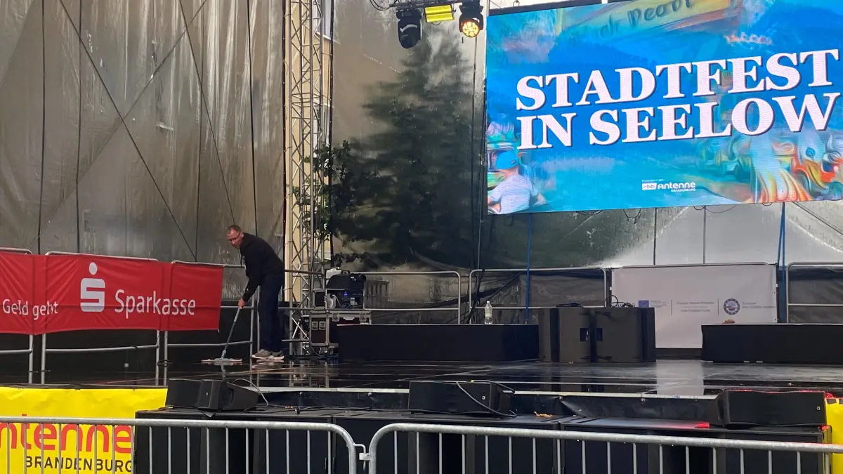 Stadtfest Seelow: Falk Angrick fegt nach einem Gewitter mit starkem Regen das Wasser von der Bühne.