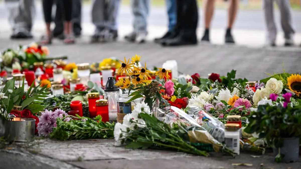 Nach der Gewalttat an einer Schule mit zwei Toten: ARCHIV - 28.08.2026, Brandenburg, Gosen-Neu-Zittau: Blumen und Kerzen liegen vor einer Schule, nach einer Gewalttat mit zwei Toten. Bei der Gewalttat im Landkreis Oder-Spree waren am Donnerstag eine Frau und ein Mann getötet worden. Ein 19 Jahre alter Deutscher gilt als Tatverdächtiger, er wurde vorläufig festgenommen und ist in Polizeigewahrsam. (zu dpa: «Wenn Männer Frauen töten: Wann ist es ein Femizid?») Foto: Britta Pedersen/dpa +++ dpa-Bildfunk +++