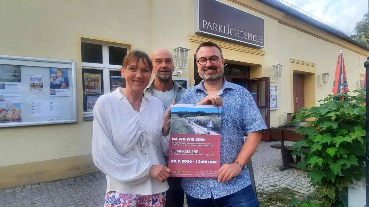 Projektleiter Nicolas Flessa (rechts) zeigt mit Kollegin Anke Denker und deren Mann Lutz, der eine Statistenrolle hat, das Filmplakat für die besondere Buckower Produktion, die nun im Kino gezeigt wird.