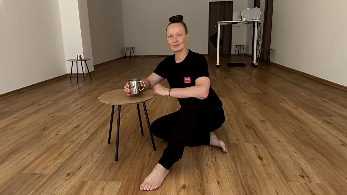 Mit Teebecher entspannt in ihrem neuen Geschäft: Monique Bodegein aus Fürstenwalde unterrichtet Taijiquan (Tai Chi) und Qigong mitten in Fürstenwalde. Warum sie dafür „Das Studio“ eröffnet hat und wie man dort an den Kursen teilnehmen kann.