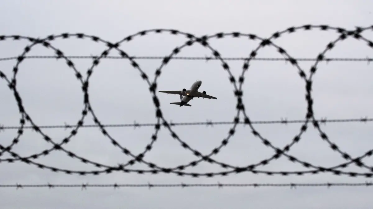 Abschiebung: ARCHIV - 06.01.2020, Niedersachsen, Hannover: Ein Flugzeug startet - fotografiert durch Stacheldraht am Flughafenzaun. (zu dpa: «13 afghanische Straftäter aus Deutschland ausgeflogen») Foto: Julian Stratenschulte/dpa +++ dpa-Bildfunk +++