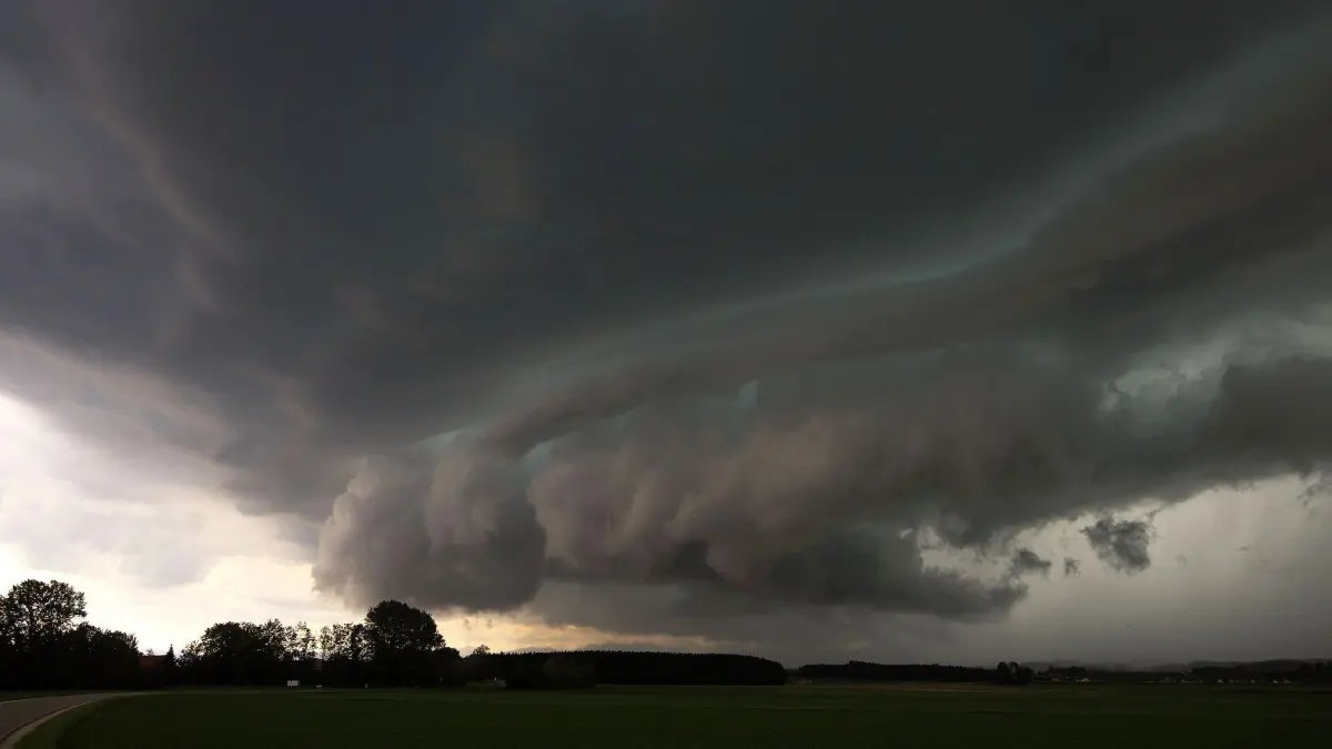 Unwetter in Bayern: 16.09.2026, Bayern, Trostberg: Dunkle Gewitterwolken ziehen am frühen Abend über dem Landkreis Traunstein in Oberbayern auf. Dunkle Wolken, heftige Schauer und teils kräftige Böen kündigen eine wechselhafte Wetterlage an. Foto: Alexander Wolf/onw-images/dpa +++ dpa-Bildfunk +++