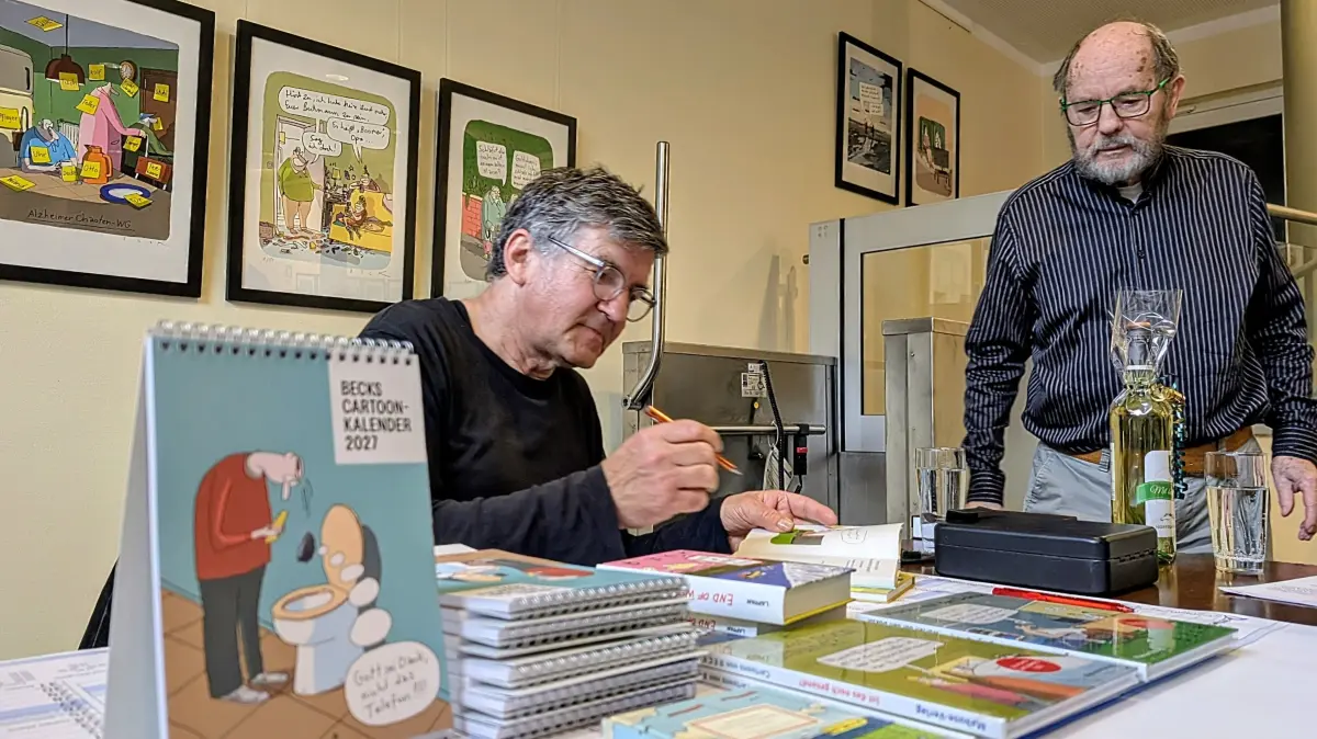 Detlef Beck beim Signieren seiner Bücher. Raymund Stolze schaut dem Meister über die Schulter.