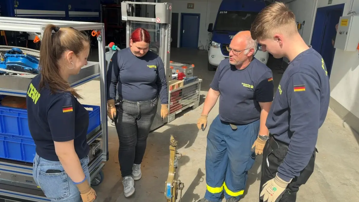 Mike Trafnik (2. v. r.) vom THW Seelow weist die neuen Bundesfreiwilligendienstleistenden Emma, Lilly und Edgar (v. l.) in die Technik des Ortsverbandes ein