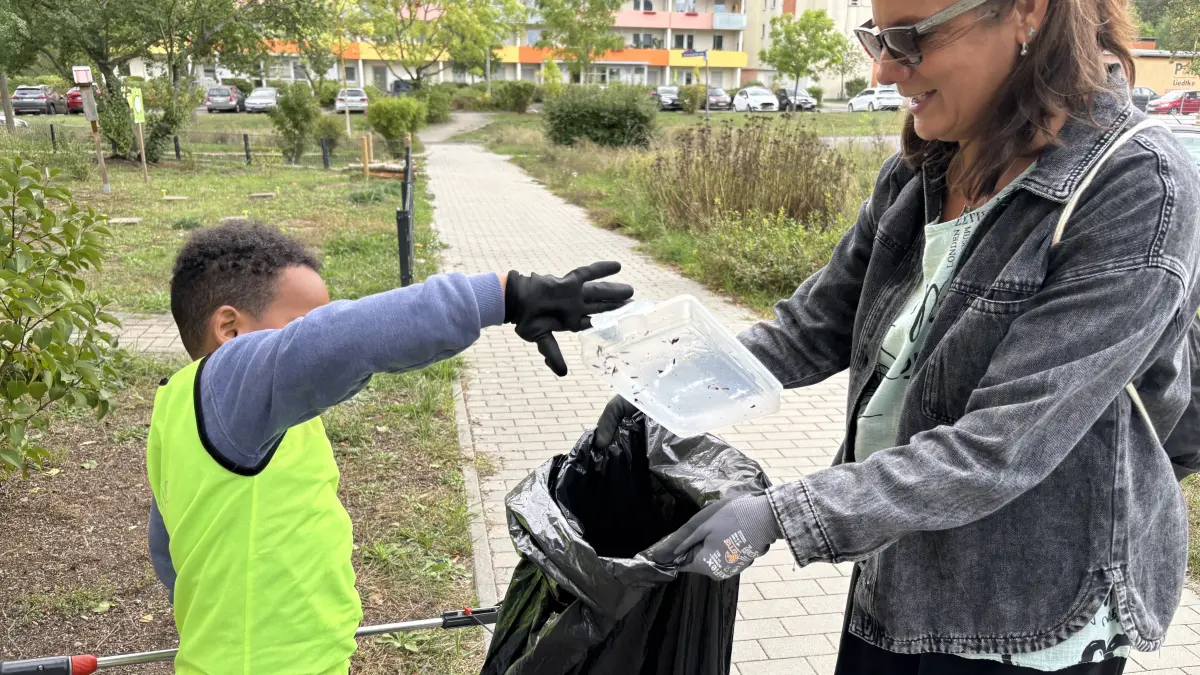 Was Erwachsene alles achtlos wegschmeißen: Plastikbehälter, Papierfetzen und vieles mehr haben die Kinder der Kita Arche Noah bei der Aktion Sauberswalde im Brandenburgischen Viertel gesammelt. Hier ein Junge mit Kitachefin Jenny Wörpel (r.).