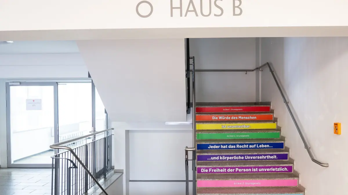 Gymnasium Cottbus: Auf einer Treppe sind am Ludwig-Leichhardt-Gymnasium mit bunten Aufklebern die ersten drei Artikel des Grundgesetzes aufgeklebt. (zu dpa: «Schülerschaft: Wir brauchen mehr Unterricht über Demokratie»)