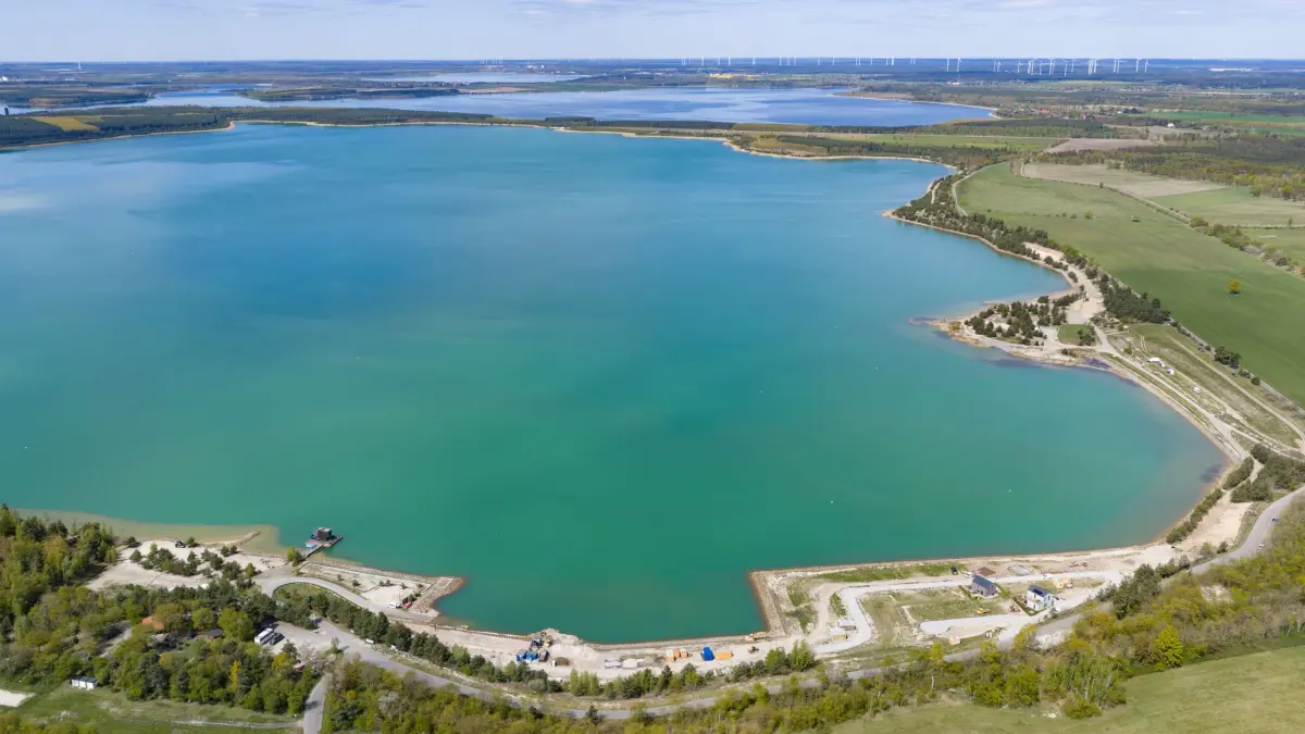 Neues Wasserrevier im Lausitzer Seenland: ARCHIV - 30.04.2026, Sachsen, Klein Partwitz: Blick auf den Partwitzer See (vorn) und und Sedlitzer See. Mit der Eröffnung des schiffbaren Seenverbundes am 29. Juni 2026 wachsen fünf große Seen erstmals zu einem zusammenhängenden Wasserrevier im Lausitzer Seenland zusammen. (Luftaufnahme mit Drohne). (zu dpa: «Center Parcs plant großen Ferienpark im Lausitzer Seenland») Foto: Robert Michael/dpa +++ dpa-Bildfunk +++