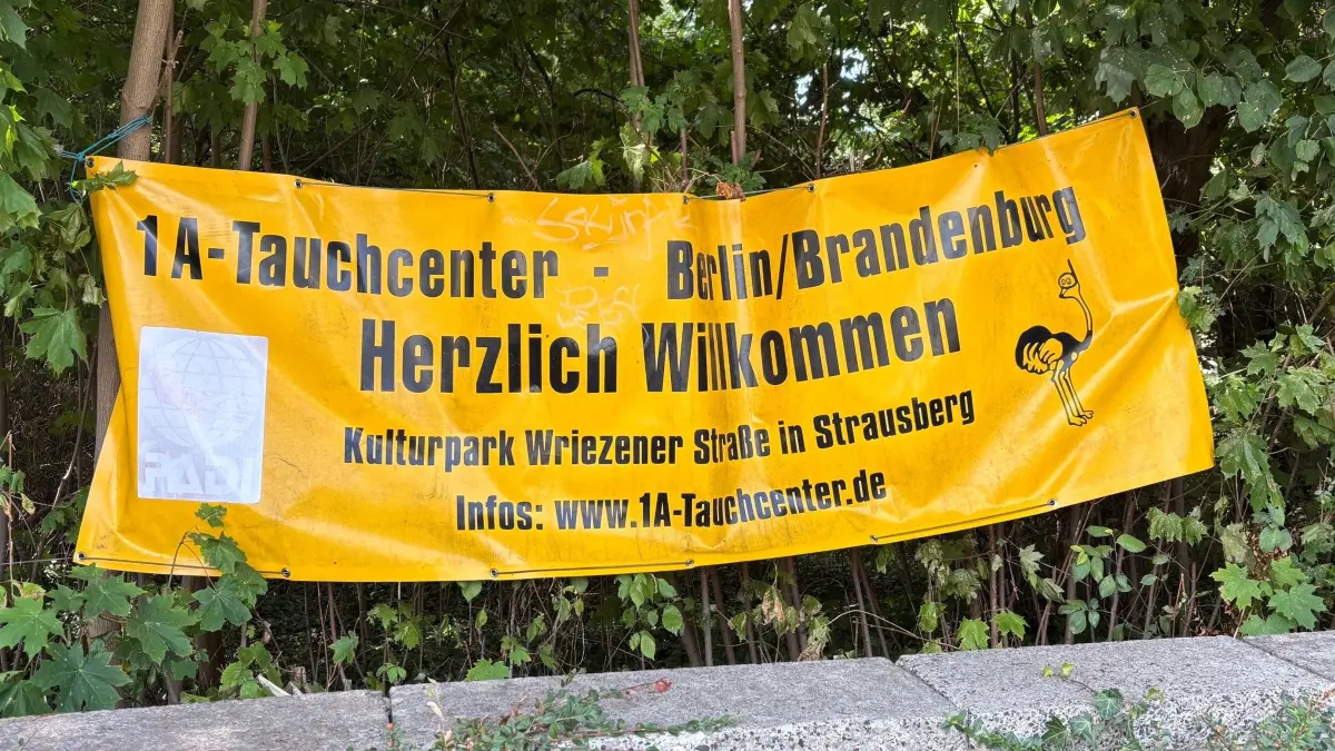 Werbung für den kommerziellen Tauchanbieter, das 1A-Tauchcenter, am Straussee in Strausberg: Noch ist nicht klar, ob die Basis bleiben kann. Die Lokalpolitik diskutiert erneut über ein finanzielles Entgegenkommen.