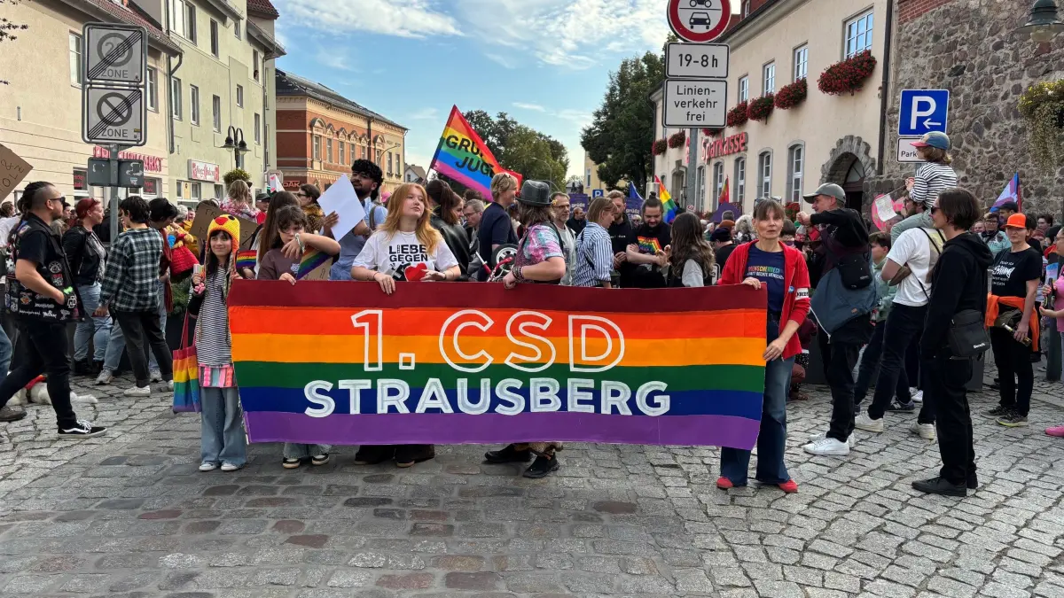 So sah es aus, als sich der Demonstrationszug des ersten Christopher Street Days in Strausberg in Bewegung setzte. Einige Teilnehmende hatten bunte Outfits gewählt und Plakate dabei.