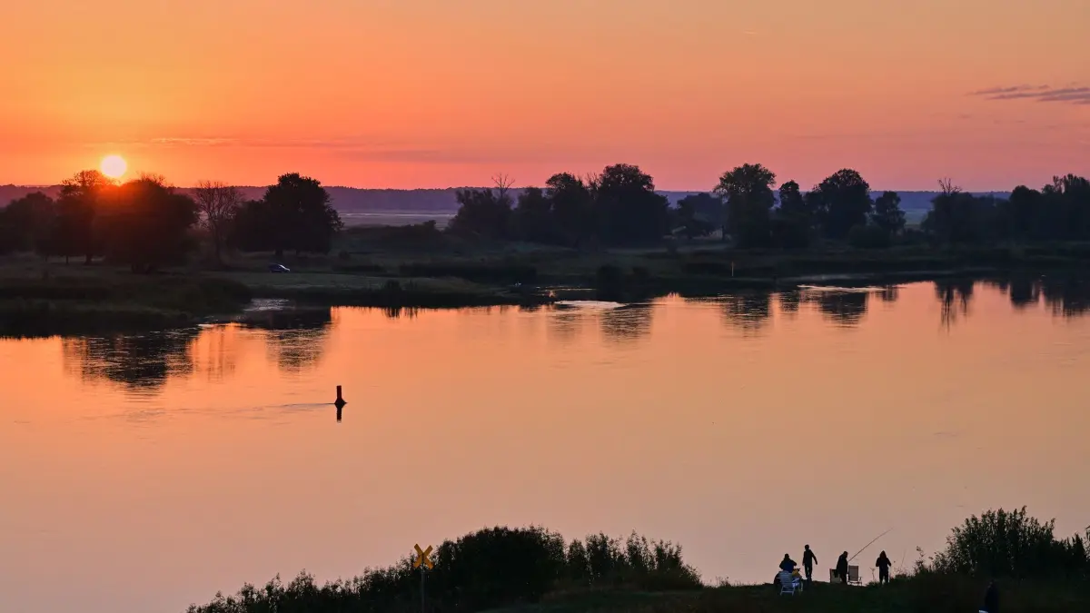 Sonnenaufgang am Fluss Oder: 27.09.2026, Brandenburg, Groß Neuendorf: Farbenprächtig leuchtet der Sonnenaufgang über dem deutsch-polnischen Grenzfluss Oder. Foto: Patrick Pleul/dpa +++ dpa-Bildfunk +++