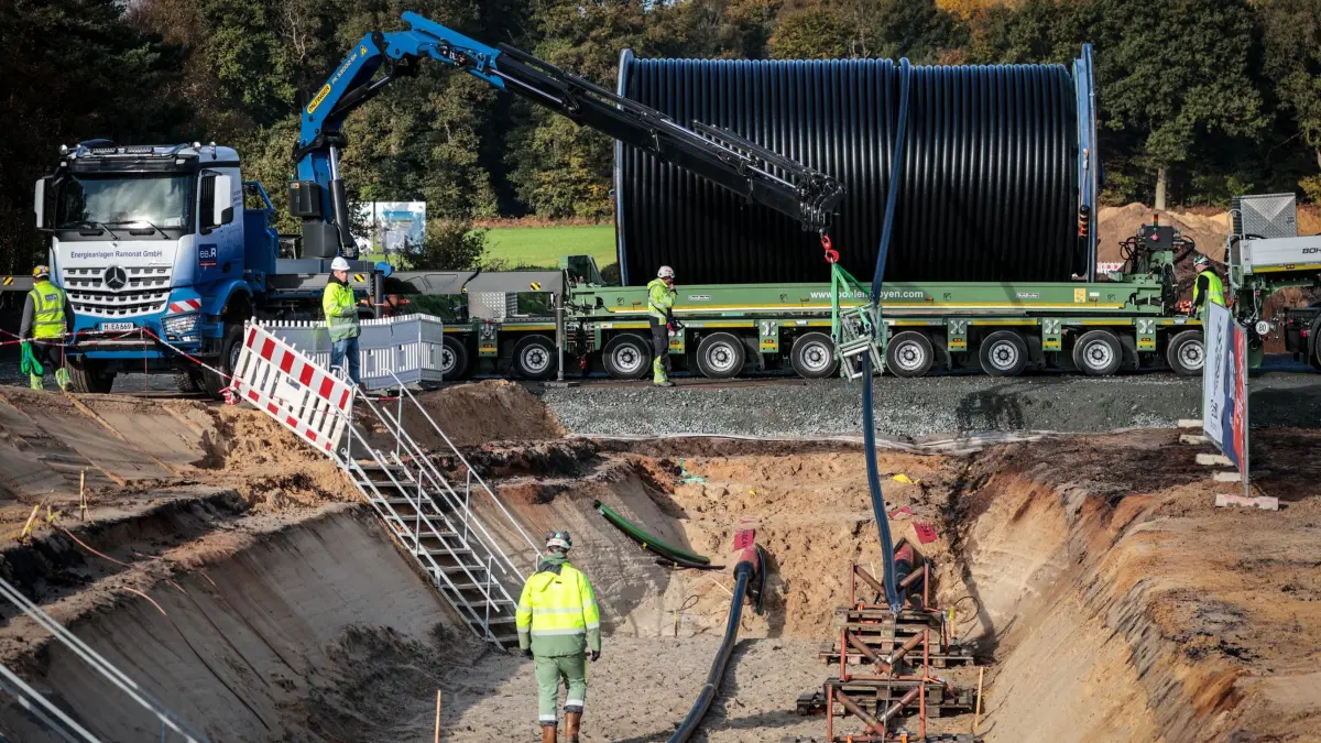 Kabelverlegung bei Suedlink: ARCHIV - 22.10.2024, Niedersachsen, Heeslingen: Ein Stromkabel wird auf einer Baustelle der Erdkabelverbindung des Stromtrassenbetreibers Tennet während des Suedlink Erdkabelpressetages von einer Trommel in einem Graben verlegt. Suedlink soll Strom aus erneuerbaren Energien von Norddeutschland in den Süden transportieren. (zu dpa: «SuedLink-Bau bei Bad Friedrichshall vorerst gestoppt») Foto: Focke Strangmann/dpa +++ dpa-Bildfunk +++