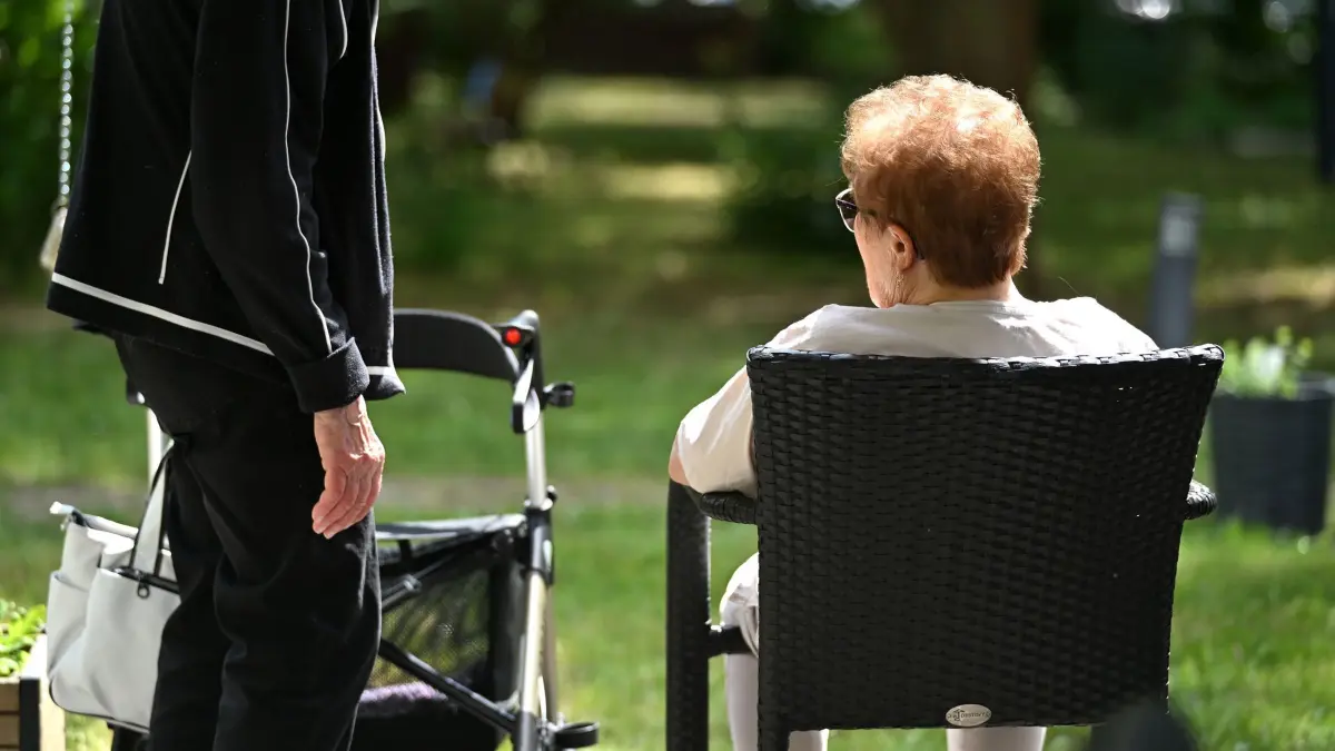 Pflegebedürftige Menschen: Zwei Senioren sprechen in dem Garten eines Pflegeheims miteinander. Hitze stellt insbesondere für ältere und pflegebedürftige Menschen ein Risiko dar. (zu dpa: «Regierung plant höhere Pflege-Beiträge für Kinderlose»)