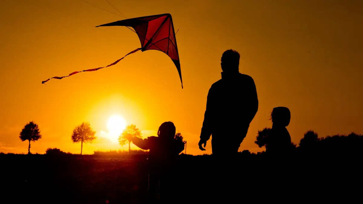 Familie lässt einen Drachen steigen: Toller Freizeitspaß für Groß und Klein: Drachensteigen. Doch ganz unvorbereitet sollten sich Familien nicht an das Hobby wagen. (zu dpa: «Drachensteigen im Herbst: Was Hobbypiloten beachten sollten»)