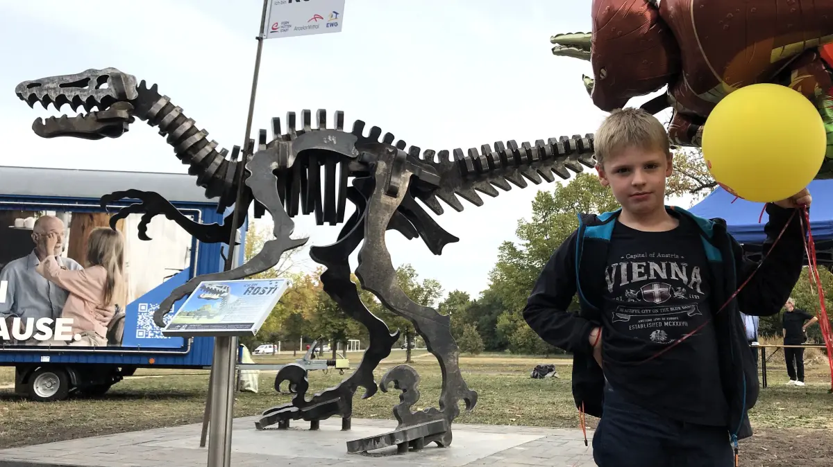 Eisenhüttenstadt. Dinosaurier aus Stahl auf dem Gelände der EWG, Karl-Marx-Straße. 4,73 m lang, 2,29 m hoch. Thorin Kahlisch (8) hatte die Idee für den Dino und durfte ihn am 02.10.2026 bei der Namensgebung offiziell einweihen. Foto: Frank Groneberg - Einverständnis beider Eltern für die Veröffentlichung wurde mündlich erteilt.
