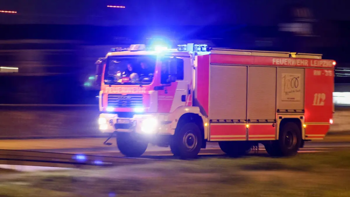 Feuerwehreinsatz: ARCHIV - 18.12.2023, Sachsen, Leipzig: Ein Löschfahrzeug der Feuerwehr fährt mit Blaulicht und Martinshorn. (zu dpa: «Zehn Autos in Carport abgebrannt - zwei Schwerverletzte») Foto: Jan Woitas/dpa +++ dpa-Bildfunk +++