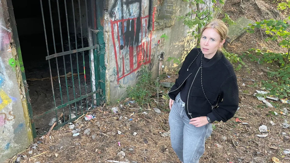 Katja Hoyer, Kommunalpolitikerin, Die Grünen, Basdorf, Wandlitz, Mitglied des Ortsbeirates, Mitglied der Gemeindevertreterversammlung. Sie steht vor einem vermüllten Bunker im Wiesenpark Basdorf, dessen Eisentür offenbar von Jugendlichen weggesprengt wurde
