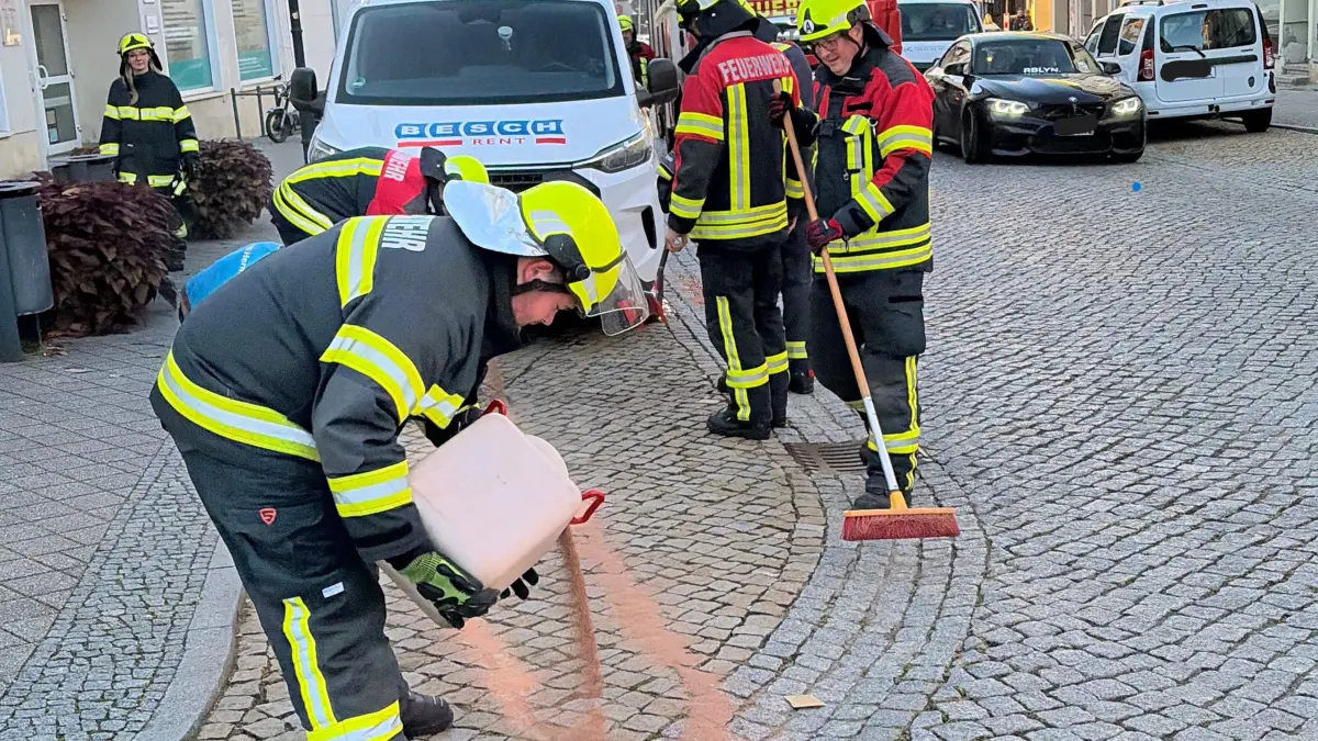Fix zur Stelle: Jannik Rasch (vorn) und Kai Krüger mit Besen nebst weiteren Einsatzkräften der Feuerwehr Bad Freienwalde benötigen viel Bindemittel, um die sich durch die Innenstadt ziehende Ölspur zu bekämpfen. Was ist passiert?