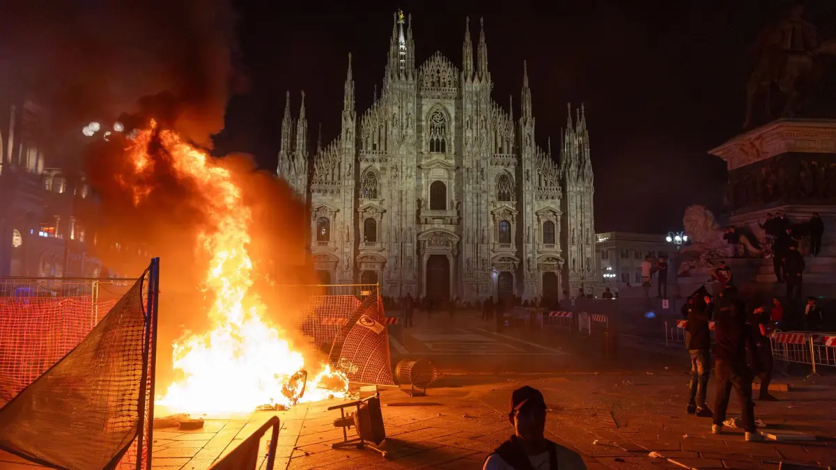 Proteste in Italien: Nach Zusammenstößen zwischen der Polizei und Demonstranten der Bewegung „Italia in Piazza“ vor dem Mailänder Dom brennt ein Feuer. (zu dpa: «Meloni kündigt nach Krawallen hartes Vorgehen an»)
