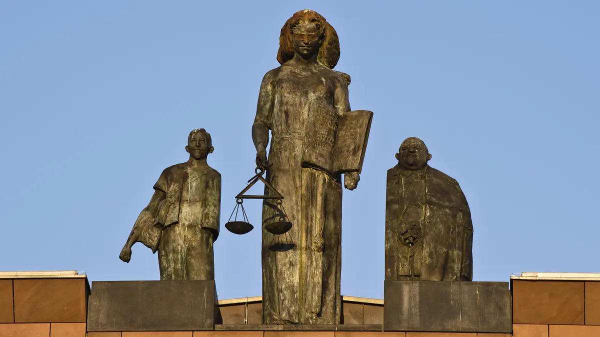 ARCHIV - Eine Statue der Justitia ist am 25.04.2013 auf dem Dach des Landgerichts Darmstadt (Hessen) zu sehen. Am 20.01.2015 startet am Landgericht in Darmstadt der Prozess gegen einen Angeklagten, der sein Opfer, bei dem er 40 000 Euro Schulden hatte, erstochen haben soll. Foto: Nicolas Armer/dpa (zu dpa/lhe «Prozess gegen einen 36-Jährigen wegen Mordverdachtes» vom 19.01.2015) +++ dpa-Bildfunk +++