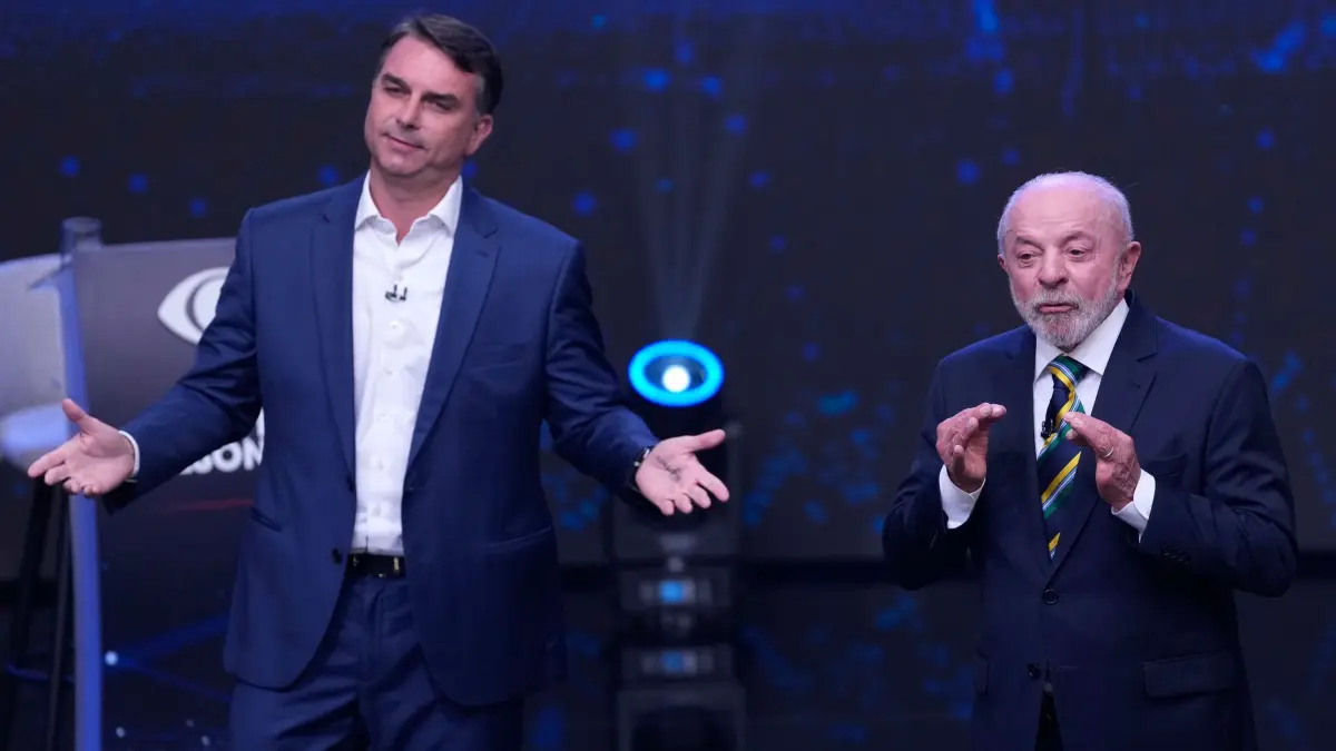 Vor den Stichwahlen in Brasilien: 18.10.2026, Brasilien, São Paulo: Der Präsidentschaftskandidat der Opposition, Senator Flavio Bolsonaro (l), breitet die Arme aus, während der brasilianische Präsident Luiz Inácio Lula da Silva während einer im Fernsehen übertragenen Präsidentschaftsdebatte eine Woche vor der Stichwahl gestikuliert. Foto: Andre Penner/AP/dpa +++ dpa-Bildfunk +++