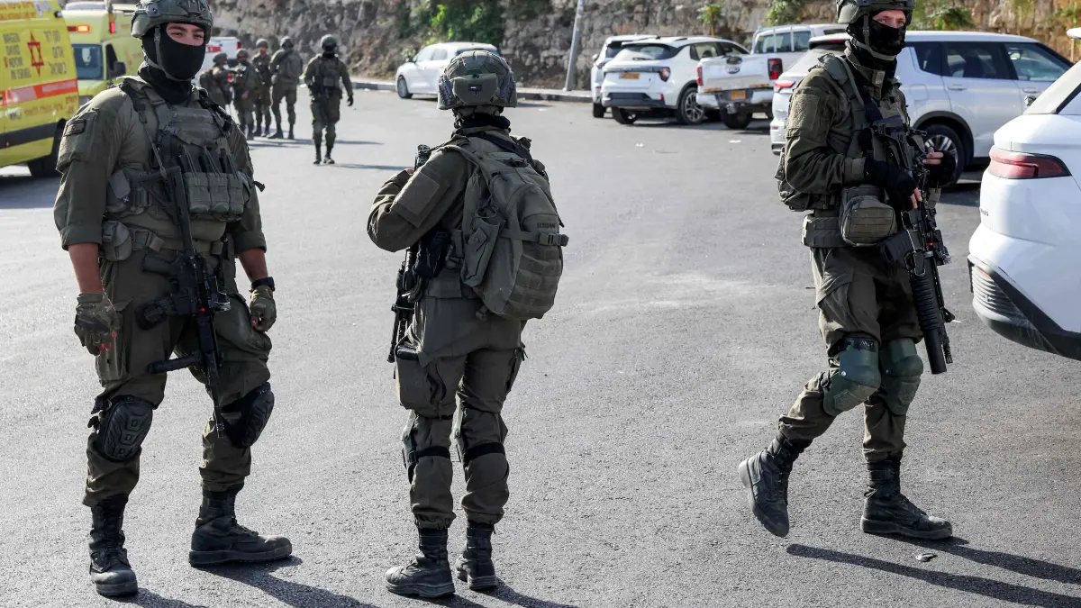 PALESTINIAN-ISRAEL-CONFLICT-WEST BANK-ATTACK: Israeli army soldiers walk at the scene following a fire exchange with armed Palestinians at the northern checkpoint of Hebron in the Israeli-occupied West Bank on October 23, 2026. Israeli troops on October 23 shot dead two suspected Palestinian assailants in the West Bank after a shooting that left at least five people wounded, officials said. (Photo by AHMAD GHARABLI / AFP)