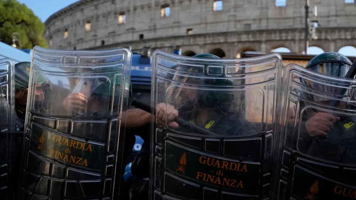 Proteste in Italien: 24.10.2026, Italien, Rom: Italienische Bereitschaftspolizisten beobachten vor dem Kolosseum Antikriegsaktivisten, die gegen die Aufrüstung und die Beteiligung Italiens an Kriegen demonstrieren. Foto: Gregorio Borgia/AP/dpa +++ dpa-Bildfunk +++