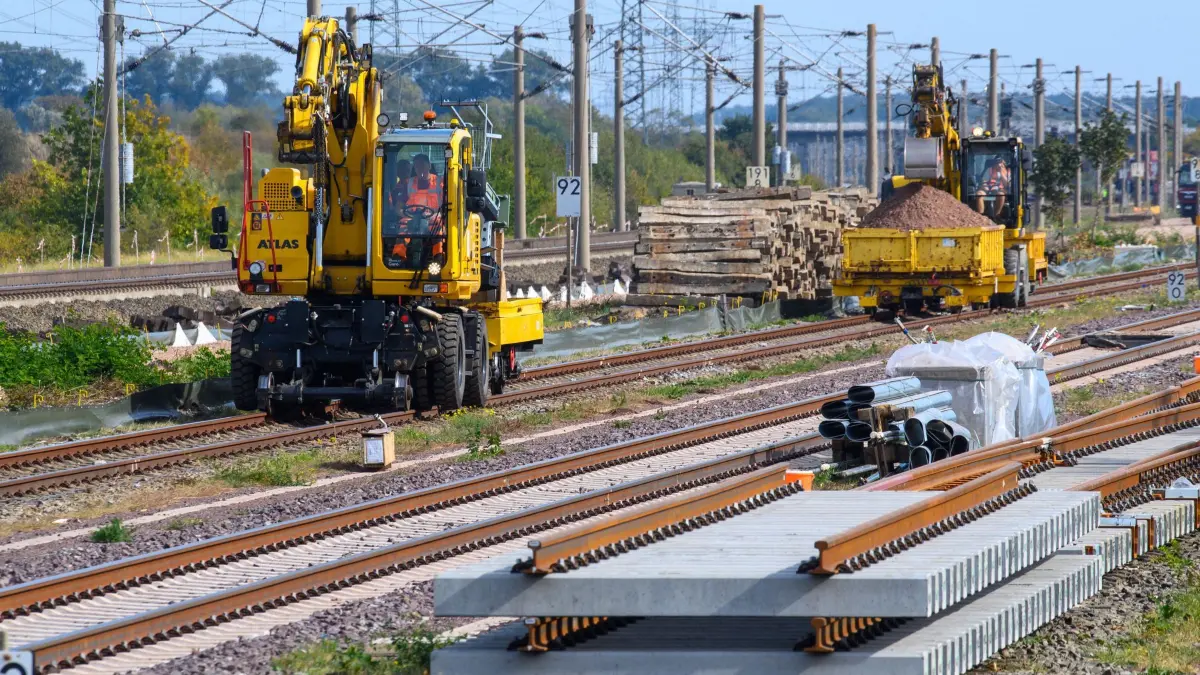 Beginn der Bahn-Bauarbeiten zwischen Hannover und Berlin: Gleisbaufahrzeuge rollen nahe des Bahnhofs Schönhausen an Gleisbauteilen vorbei. Die "DB InfraGO" startet am 2. Oktober 2026 mit den Bauarbeiten entlang der Ost-West-Achse zwischen Hannover und Berlin. In den kommenden Monaten wird auf der Schnellfahrstrecke östlich und westlich von Stendal die Feste Fahrbahn erneuert. Gleichzeitig wird die Elektrifizierung der parallel verlaufenden Lehrter Stammbahn weitergebaut. (zu dpa: «Rechnungshof sieht Fehlentwicklungen bei Bahn-Sanierungen»)