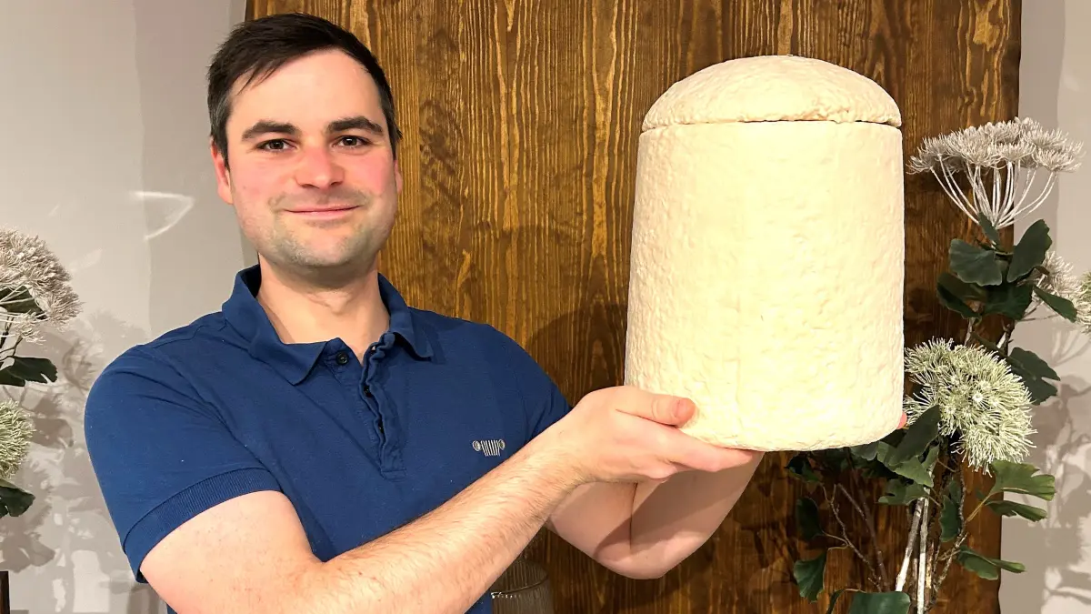 Noch eher selten in Eberswalde: Christian Haas vom Bestattungshaus Deufrains zeigt eine Urne, die aus Pilzmyzel und recycelten Hanffasern besteht. Was passiert mit diesem Material im Boden?