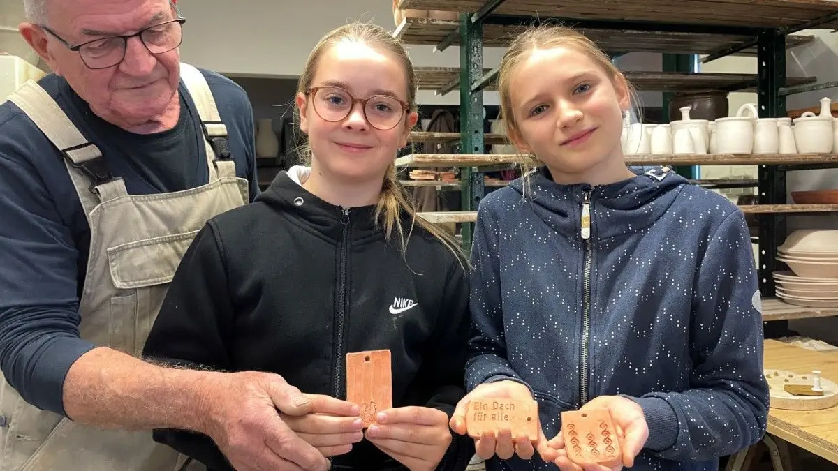 Kliene Tonziegle geformt: Unter Anleitung von Töpfer Manfred Dannegger (77) haben haben am Reformationstag Laura und Abby (beide 9) diese Ziegel gestaltet. Mit dem Kauf wird die Sanierung der Kirche Wilhelmsaue gefördert.